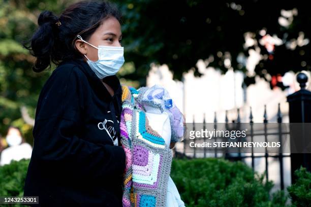 Migrant from Venezuela, who boarded a bus in Texas, waits to be transported to a local church by volunteers after being dropped off outside the...