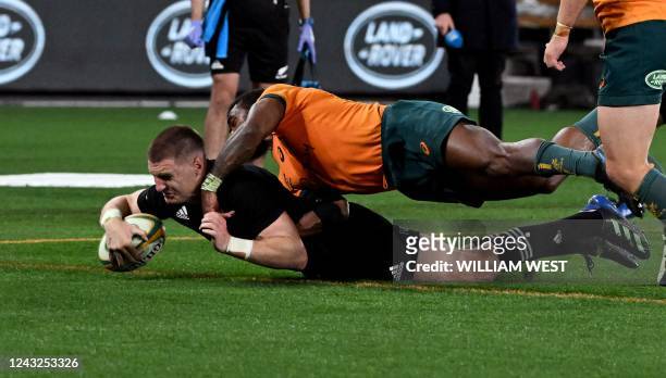 New Zealand's Jordie Barrett scores a last minute try as he is tackled by Australia's Marika Koroibete during the Rugby Championship match between...
