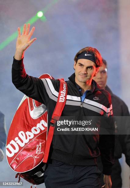 Roger Federer of Switzerland waves to his fans as he enters the court prior an exhibition match against US James Blake on November 18, 2008 in Kuala...
