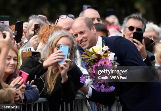 William, Prince of Wales, takes a selfie with a woman gathered outside Sandringham Estate, following the death of Britain's Queen Elizabeth, on...