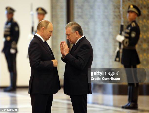 Russian President Vladimir Putin talks to Uzbek President Shavkat Mirziyoyev during their meeting at the Shanghai Cooperation Organization Summit on...