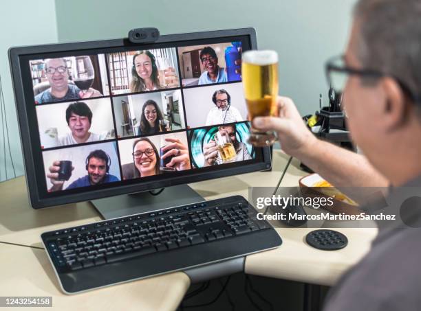 adult man on conference call drinking beer with friends doing happy hour - online happy hour stock pictures, royalty-free photos & images