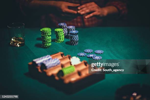 bunch of gambling chips in front of a man in casino - gambling table stock pictures, royalty-free photos & images