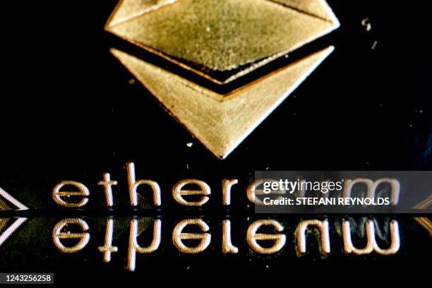 In this photo illustration created in Washington, DC, on September 15 the Ethereum logo on a physical imitation of an Ethereum cryptocurrency is...