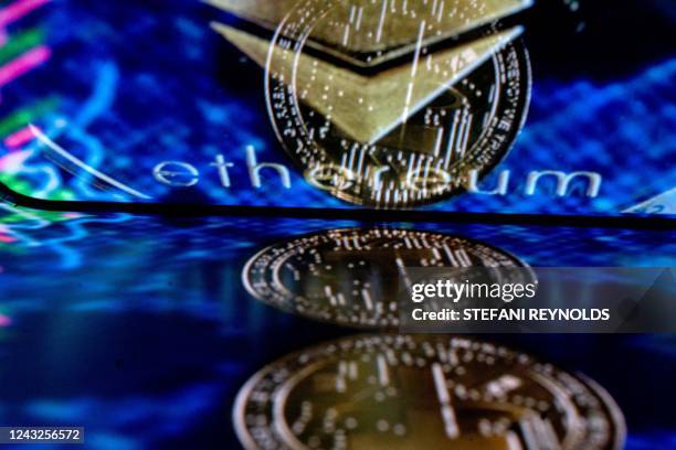 In this photo illustration created in Washington, DC, on September 15 the Ethereum logo and a physical imitation of an Ethereum cryptocurrency are...