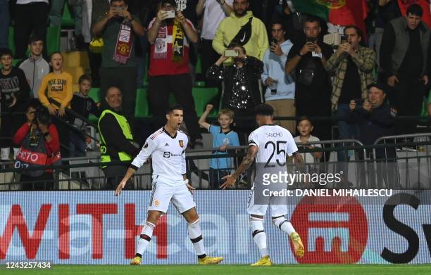 Manchester United's Portuguese striker Cristiano Ronaldo celebrates with Manchester United's English striker Jadon Sancho after scoring the 0-2 from...