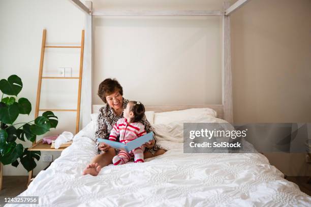 grandma reading a story - grandmother granddaughter stock pictures, royalty-free photos & images