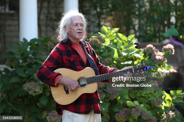 Martha's Vineyard, MA A man plays the guitar outside St. Andrews Episcopal Church. Two planes of migrants from Venezuela arrived suddenly Wednesday...