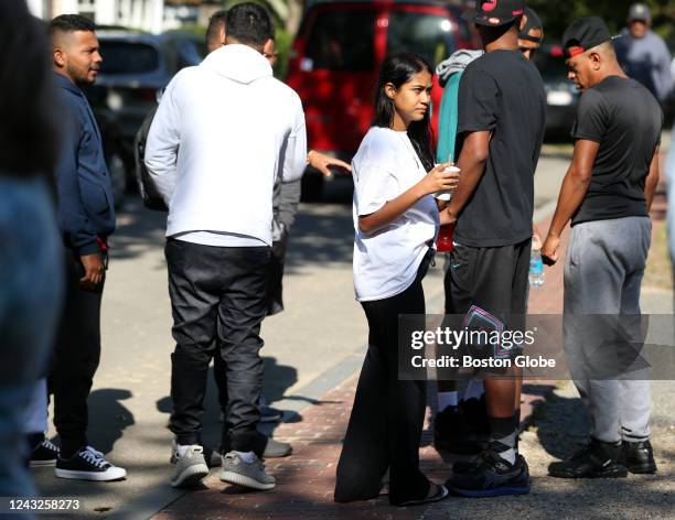 Martha's Vineyard, MA A group of migrants huddle on a sidewalk in front of St. Andrews Episcopal Church. Two planes of migrants from Venezuela...