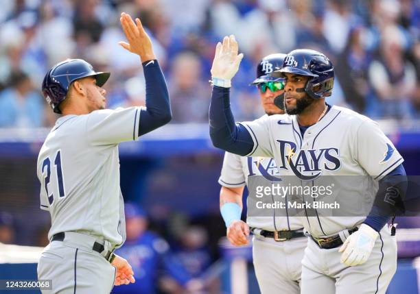 Yandy Diaz of the Tampa Bay Rays celebrate this home run with Rene Pinto against the Toronto Blue Jays in the second inning during their MLB game at...