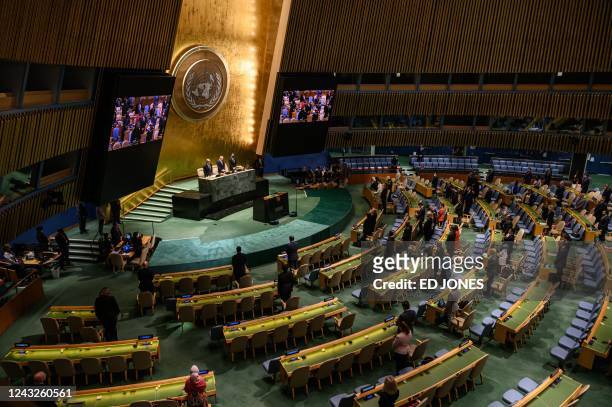 Attendees of a General Assembly meeting stand in silence during a tribute to Britain's Queen Elizabeth, at the United Nations headquarters in New...