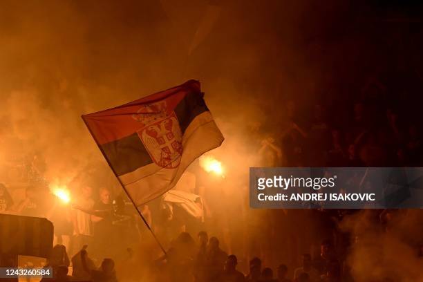 Partizans supporters hold a Serbia's national flag and light flares during the UEFA Europa Conference League football match between Partizan and Nice...
