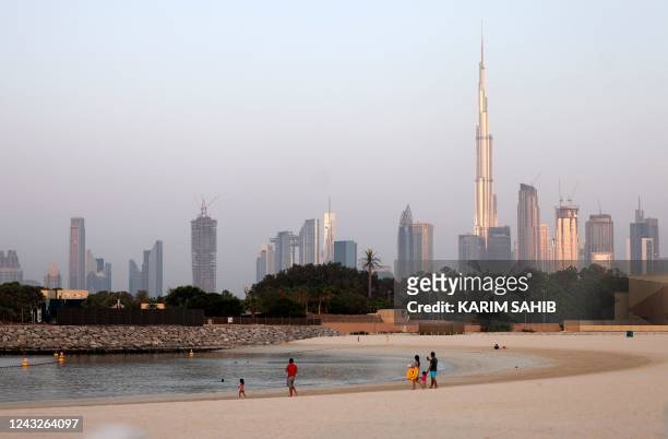 People gather at a beach in the Gulf emirate of Dubai, on September 15, 2022. - The United Arab Emirates did not qualify for the Qatar World Cup but...