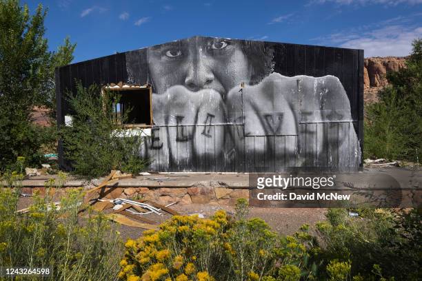 In a mural by Chip Thomas, the letters, BELIEVE, appear on a Navajo man's fingers on September 6, 2022 at Tsegi, Arizona. Murals and graffiti are...