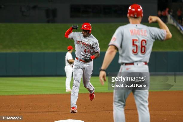 Aristides Aquino and J.R. House of the Cincinnati Reds celebrate as Aquino runs the bases after hitting a solo home run during the sixth inning...