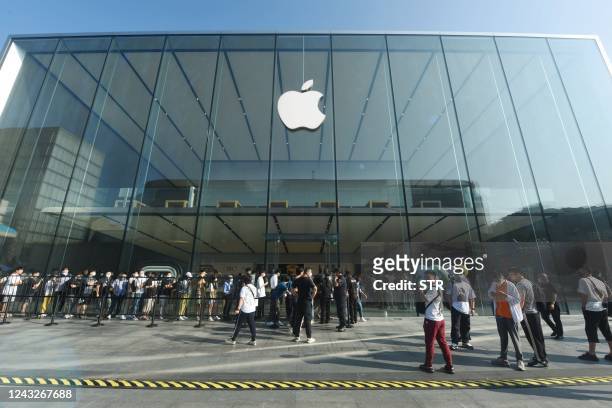 Customers queue to get newly-launched iPhone 14 mobile phones at an Apple store in Hangzhou, in China's eastern Zhejiang province on September 16,...