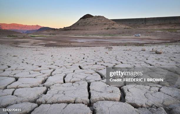 Vehicle drives past a dry, cracked lake bed on its way to Boulder Harbour in drought-stricken Lake Mead on September 15, 2022 in Boulder City,...