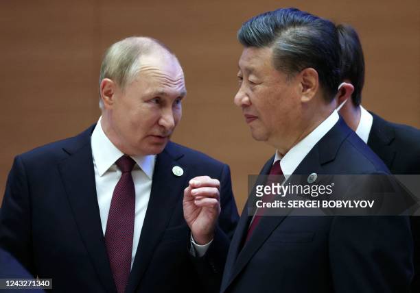 Russian President Vladimir Putin speaks to China's President Xi Jinping during the Shanghai Cooperation Organisation leaders' summit in Samarkand on...