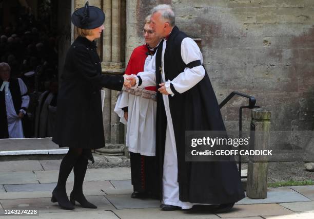 Britain's Prime Minister Liz Truss shakes hands with the Archbishop for Wales Andrew John as she leaves after attending a Service of Prayer and...