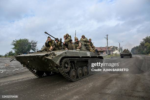 Ukrainian soldiers sit on infantry fighting vehicles as they drive near Izyum, eastern Ukraine on September 16 amid the Russian invasion of Ukraine.