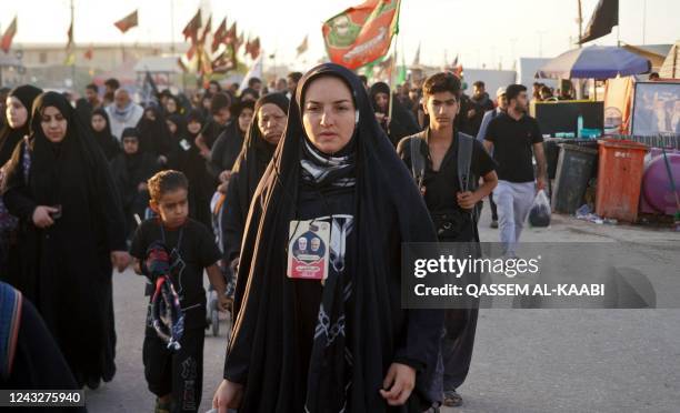 Woman wears a necklace bearing pictures of slain Iranian and Iraqi commanders, respectively Qasem Soleimani and Abu Mahdi al-Muhandis, as Shiite...