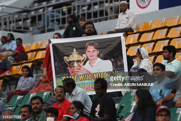 Man holds a placard with a picture of Swiss tennis player Roger Federer during their WTA Tour Chennai Open 2022 quarterfinal singles tennis match...