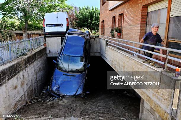 Photograph shows damages cars in front of a flooded house following an overnight rain bomb in Pianello di Ostra, Ancona province, on September 16,...