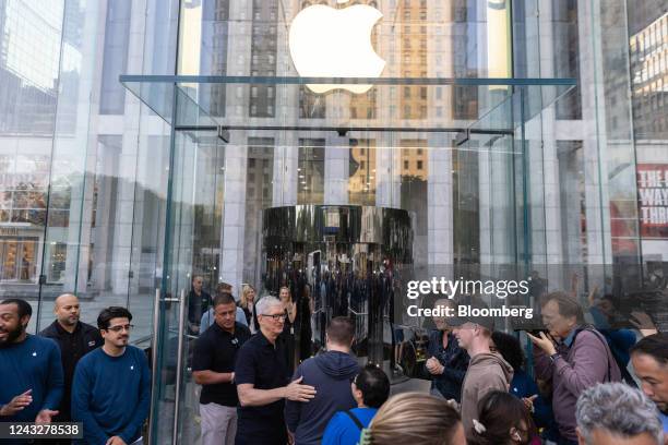 Tim Cook, chief executive officer of Apple Inc., center left, greets shoppers outside the Apple Fifth Avenue store in New York, US, on Friday, Sept....