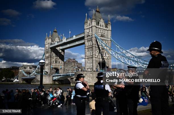 Members of the public stand in the queue near Tower Bridge, as they wait in line to pay their respects to the late Queen Elizabeth II, in London on...