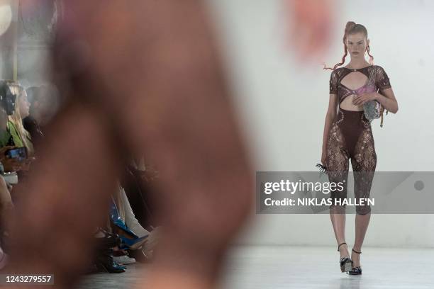 Models present creations by British designer Poster Girl during a catwalk show on the second day of London Fashion Week June Edition in London on...