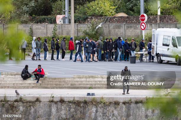 Migrants line up to get a meal delivered by associations in the city centre of Calais on September 16, 2022. - Migrant aid associations criticised on...