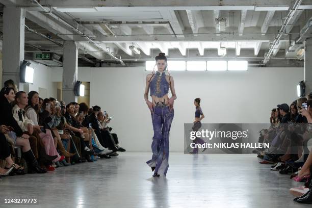 Models present creations by British designer Poster Girl during a catwalk show on the second day of London Fashion Week June Edition in London on...