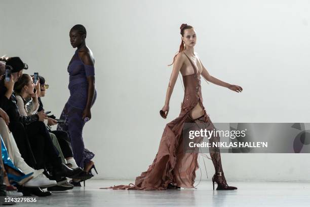 Models present creations by British designer Poster Girl during a catwalk show on the second day of London Fashion Week June Edition in London on...