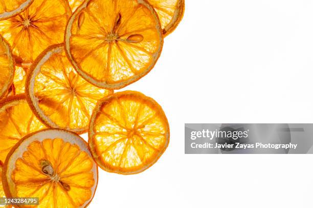 many dried orange slices on a white background in a bright light - dried food stock pictures, royalty-free photos & images