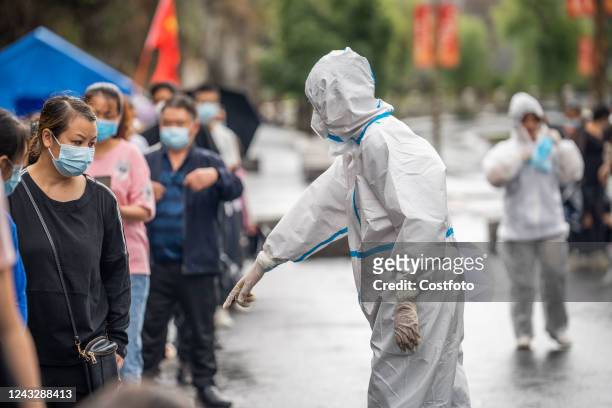 Citizens line up for nucleic acid tests at a nucleic acid screening point in a residential community in Bijie, Guizhou province, Sept 16, 2022.