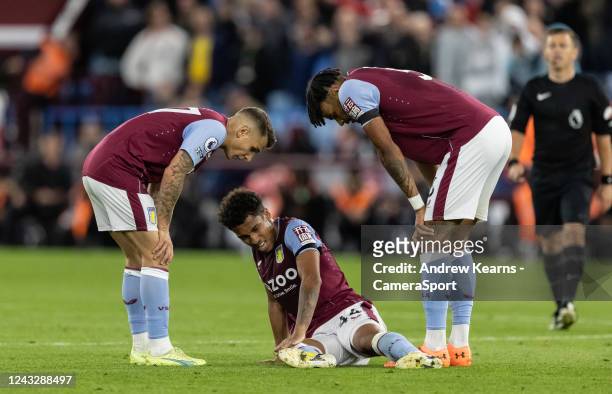 Concerned team mates Lucas Digne and Tyrone Mings enquire on the health of Aston Villa's Boubacar Kamara during the Premier League match between...