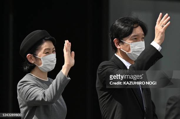 Japanese Crown Prince Akishino and Crown Princess Kiko wave as they see off the departure of the plane carrying the emperor and empress to attend the...