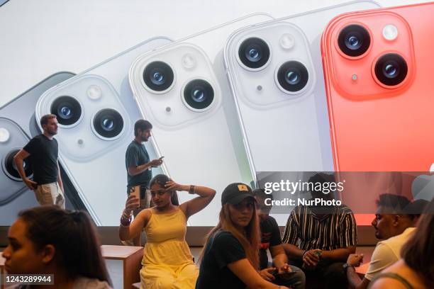 Apple salespeople serve customers who want to buy the new iPhone 14 and exchange impressions and advise them, in Barcelona, Spain, on September 16,...