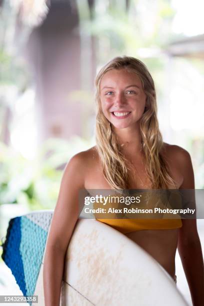 a young blond-haired woman in swimwear holding her surfboard - el salvador woman stock pictures, royalty-free photos & images