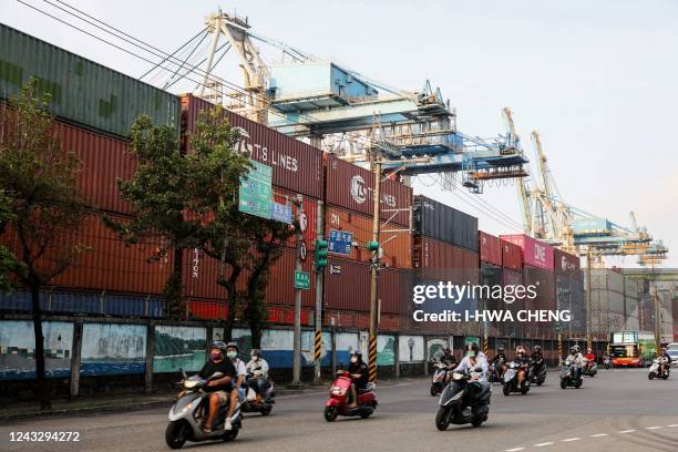 Motorists commute past shipping containers at the port in Keelung on September 17, 2022.