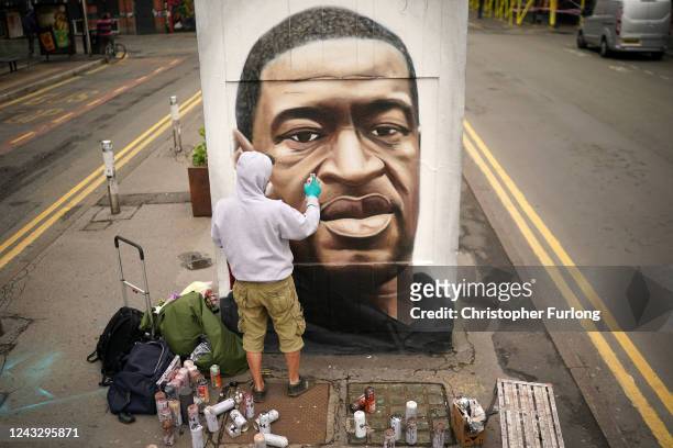 Graffiti artist Akse spray paints a mural of George Floyd in Manchester's northern quarter on June 03, 2020 in Manchester, United Kingdom. The death...