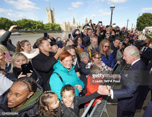 King Charles III meets members of the public in the queue along the South Bank, near to Lambeth Bridge, as they wait to view Queen Elizabeth II lying...