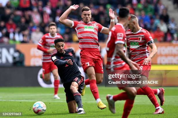 Bayern Munich's Moroccan defender Noussair Mazraoui and Augsburg's Bosnian forward Ermedin Demirovi? vie for the ball during the German first...
