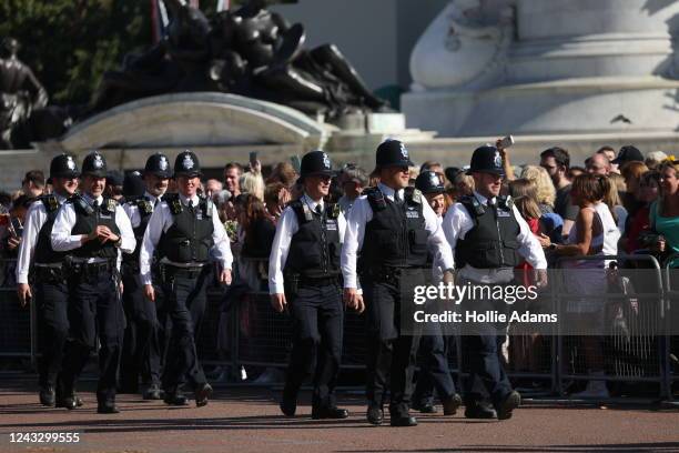 Police patrol as crowds gather outside Buckinham Palace by the Queen Victoria Memorial as people visit to pay respects to Queen Elizabeth on...