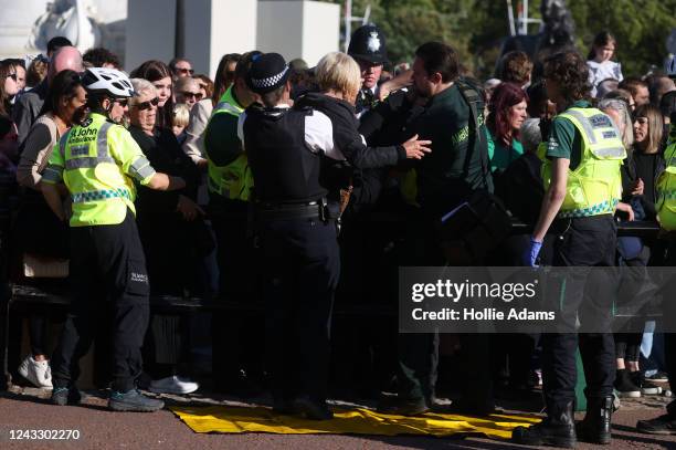 Member of the public is lifted over the barrier at Buckingham Palace by Police and paramedics on September 17, 2022 in London, United Kingdom. Queen...