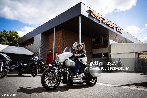 Dominique aka "Dodo" a French woman biker poses on her motorcycle in front of a Harley Davidson dealer in Villiers-sur-Marne, eastern Paris, on...