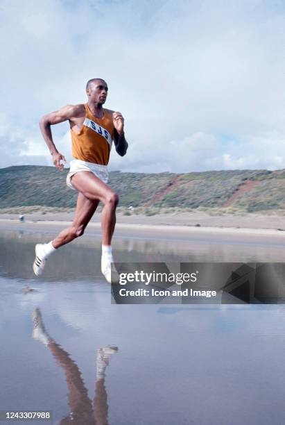 American track & field athlete, wide receiver, Olympic gold medalist and activist Tommie Smith trains on the beach, 1966.