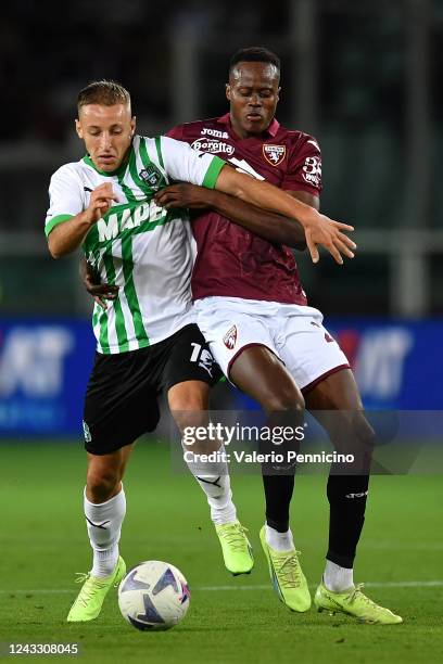 Demba Seck of Torino FC competes with Davide Frattesi of US Sassuolo during the Serie A match between Torino FC and US Sassuolo at Stadio Olimpico di...