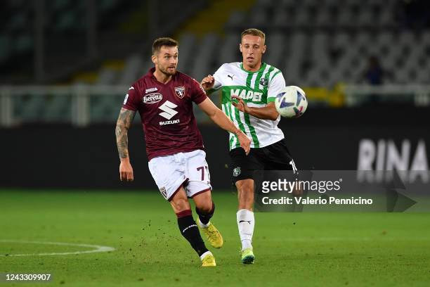 Karol Linetty of Torino FC is challenged by Davide Frattesi of US Sassuolo during the Serie A match between Torino FC and US Sassuolo at Stadio...