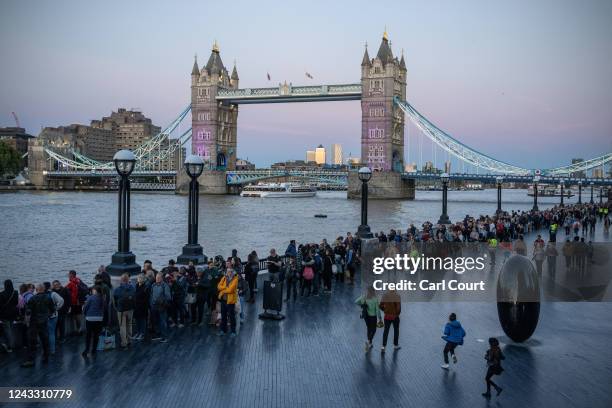 People queue past Tower Bridge as they wait to pay their respects to Queen Elizabeth II as she lies in state in Westminster Hall on September 17,...